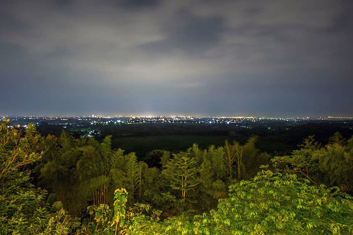 Panorama kota dengan semburat cahaya lampu di malam hari